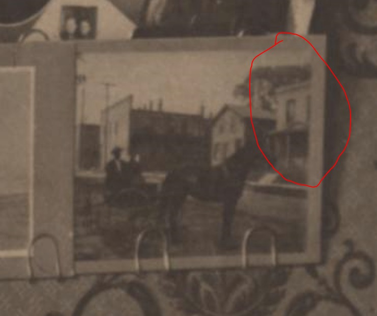 Among the photos on the wall, this seems to show Anna Morgan's house (circled in red). My guess would be that this is Anna's father, Thomas Morgan, in his horse and buggy.